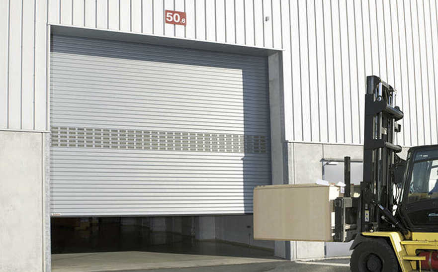 Technician performing commercial garage door repair in Coral Springs with professional tools and equipment.
